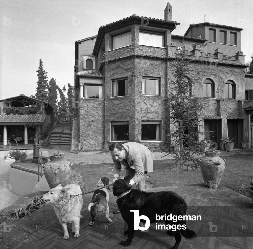 Alberto Sordi playing with his dogs, Italy, 1960 (b/w photo)
