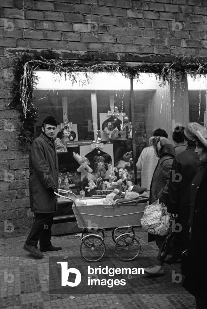 Some people watching a shop window on Christmas' Eve, Prague, Czech Republic, December 1968 (b/w photo)