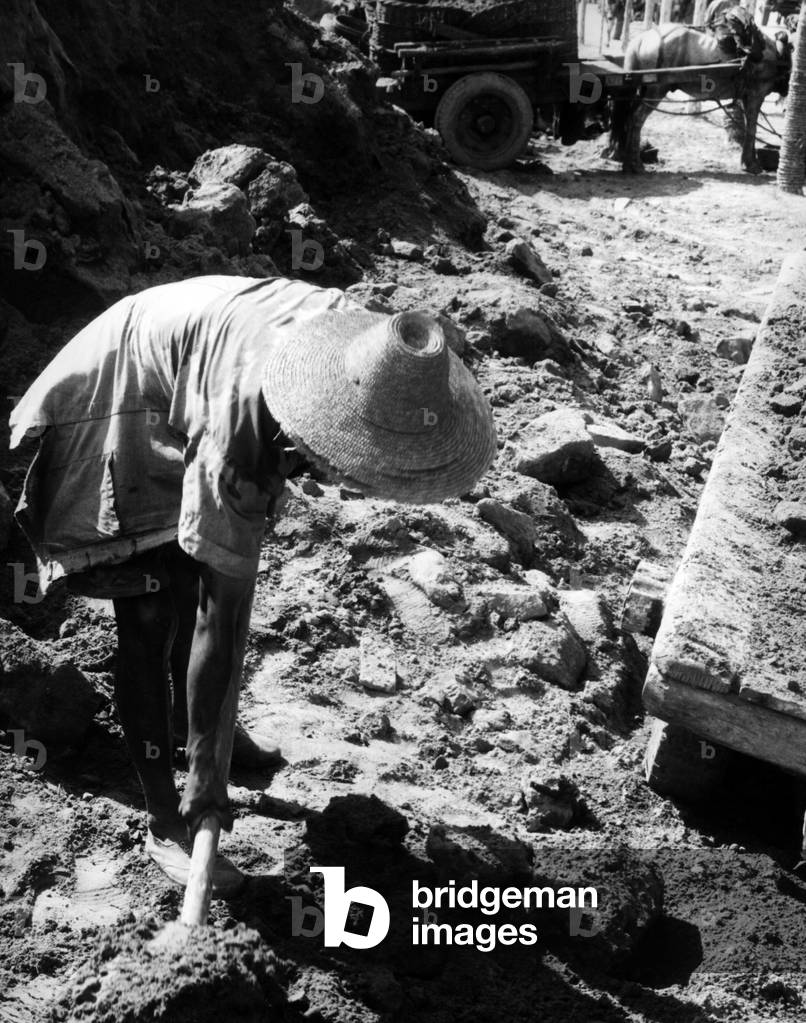 A woman cultivating the ground