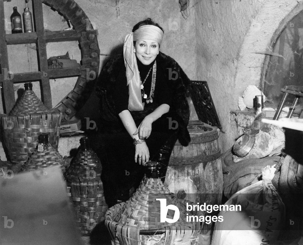 Valentina Cortese among the wine demijohns, Portofino, Italy, 1969