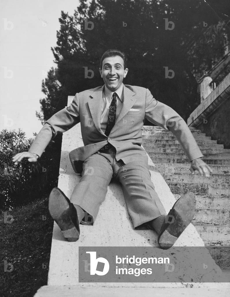 Pippo Baudo sliding on a balustrade