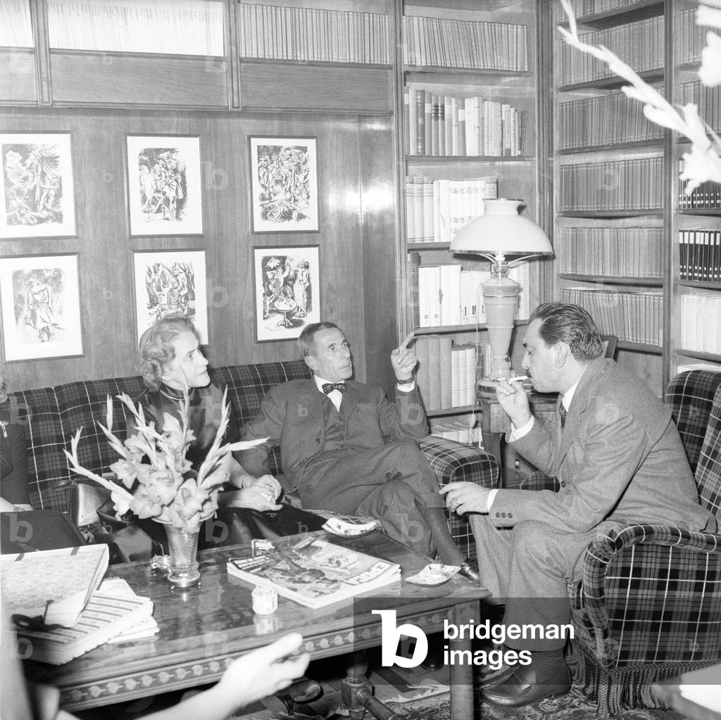 Gianna Manzini talks with Dino Buzzati and Alberto Mondadori in a living room