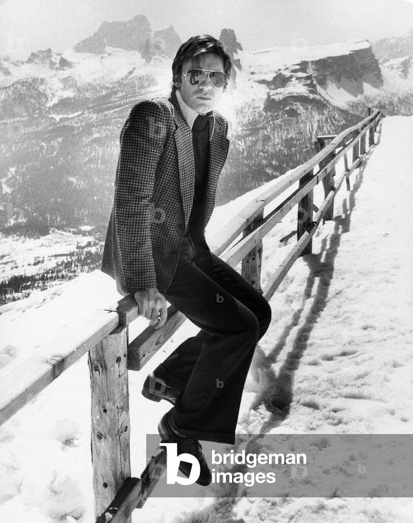 Helmut Berger sitting on a paling