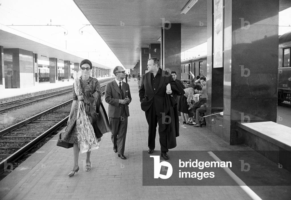 Orson Welles and Paola Mori arriving at Termini railway station, Italy, 1962 (b/w photo)