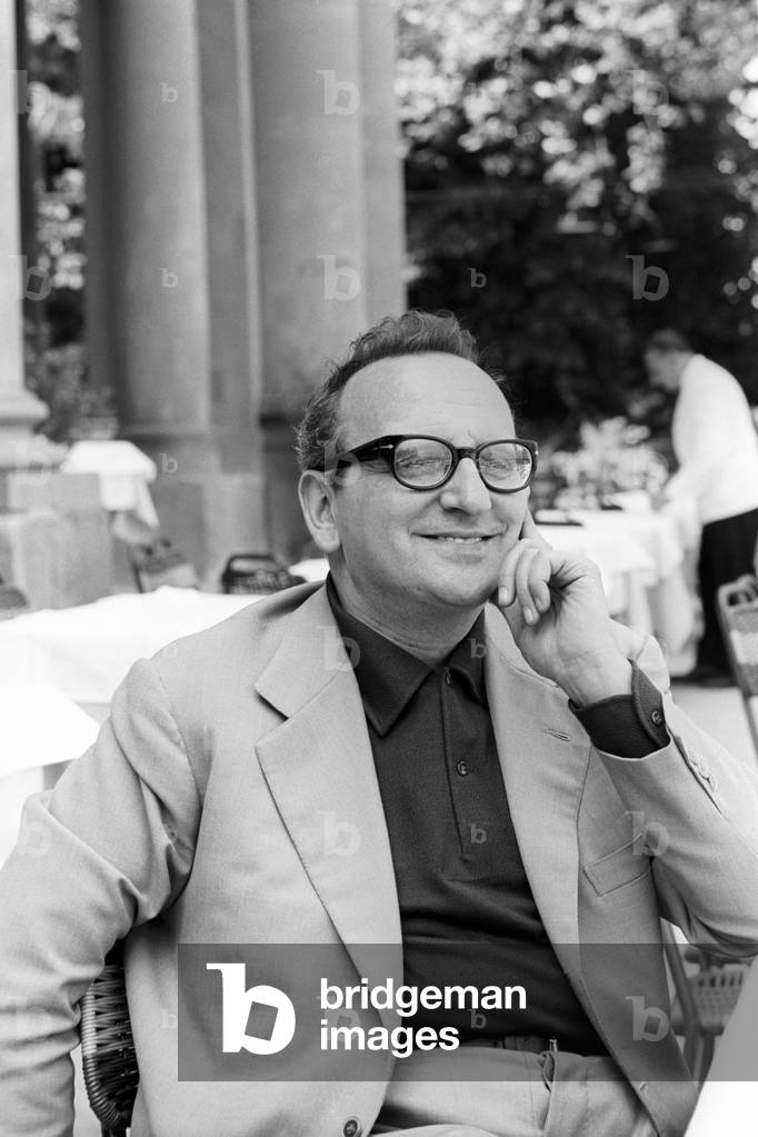 Vasco Pratolini sitting at a table outdoors