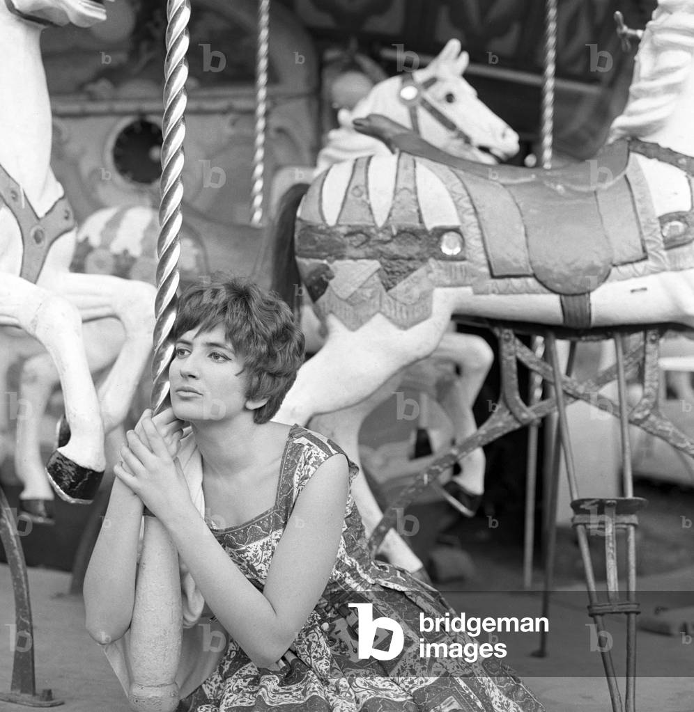 Mina leaning on a carousel, Italy, 1960 (b/w photo)