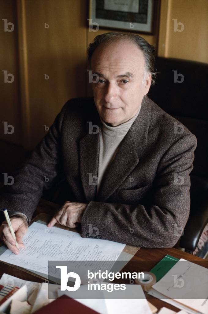 Poet Andrea Zanzotto seated at a desk