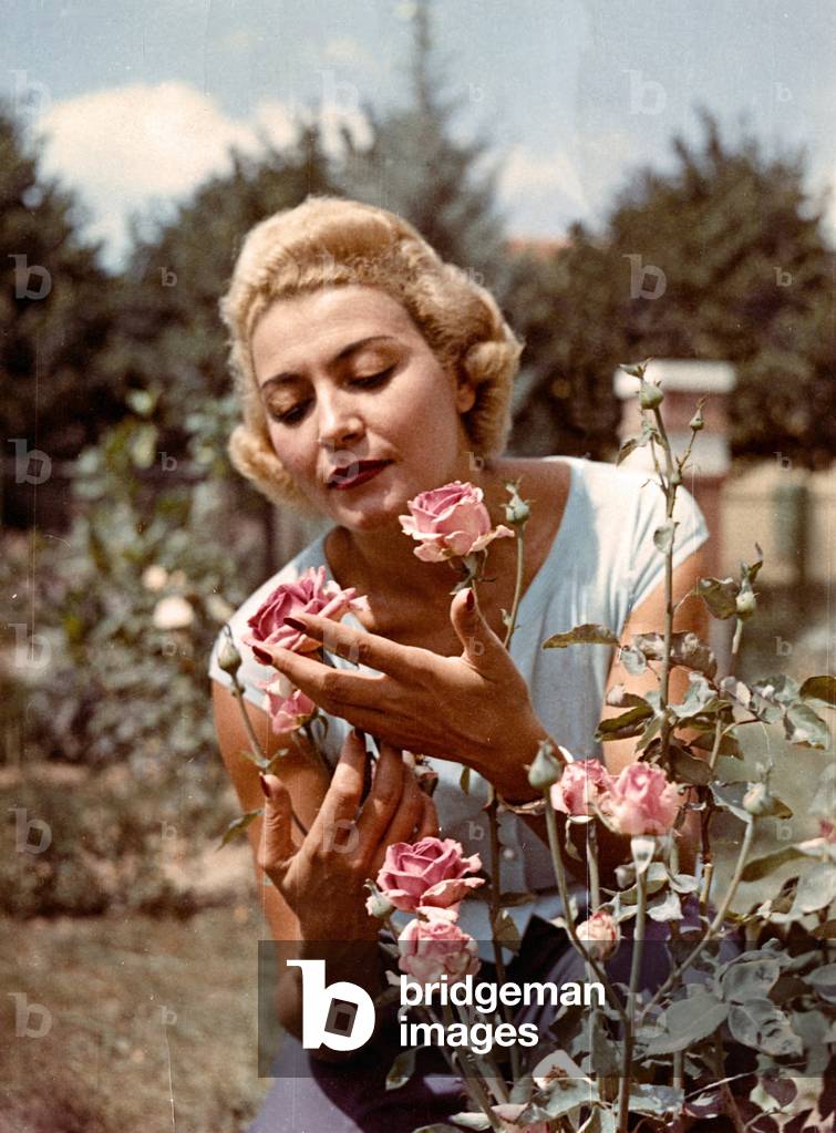 Nilla Pizzi touching a rose