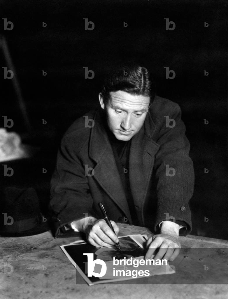 Spencer Tracy signing a picture