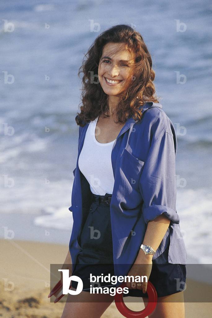 Barbara D'Urso smiling on a beach