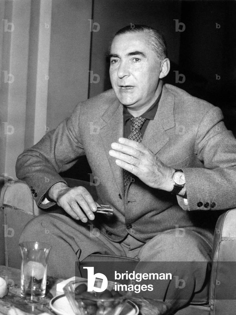 Writer Curzio Malaparte seated in an armchair