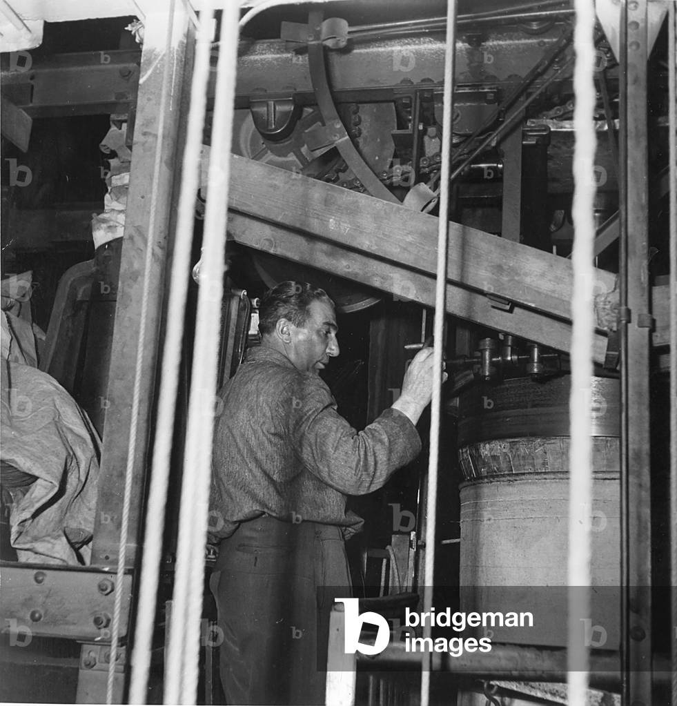 A technician controlling a mechanism, Italy, 1953 (b/w photo)