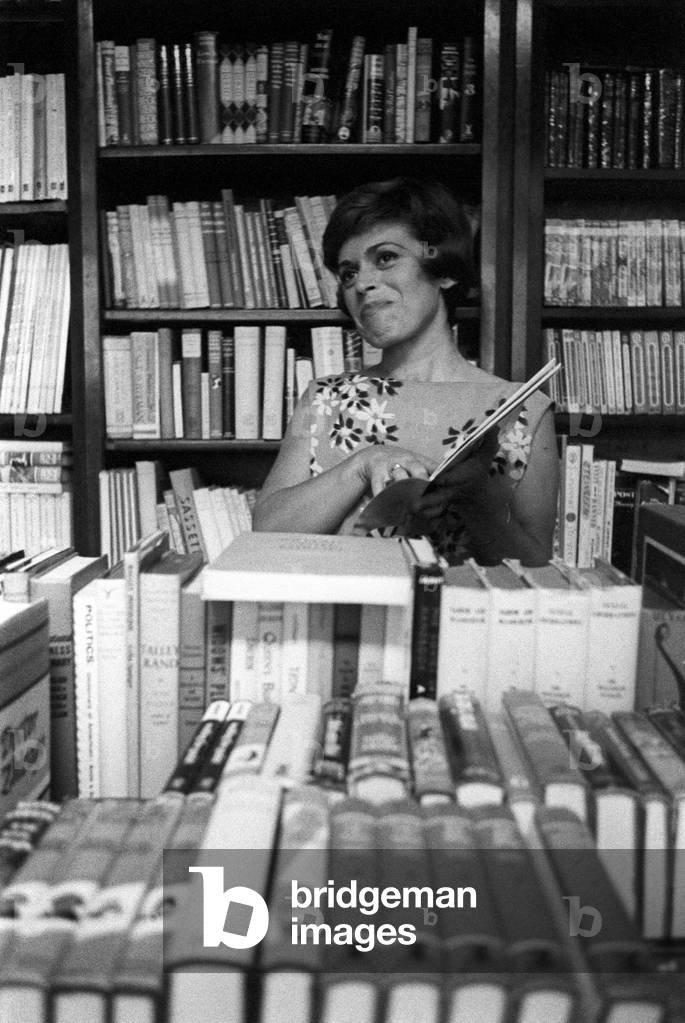 Franca Valeri behind bookshelves of a bookshops