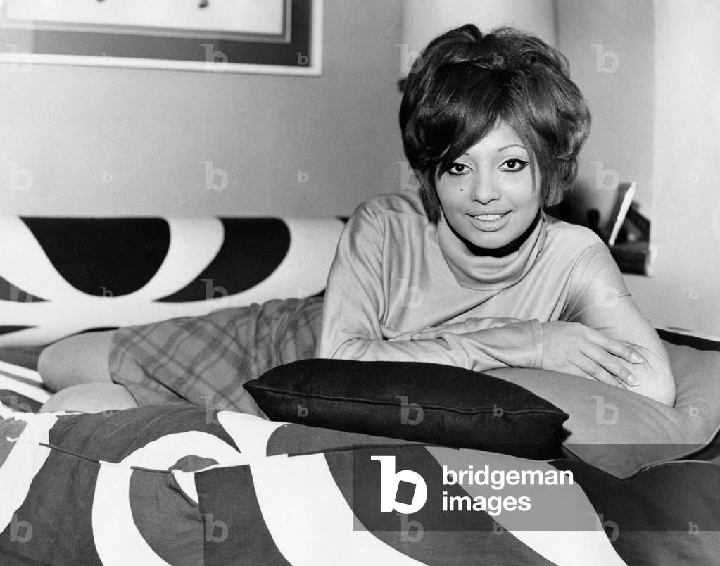 Lara Saint Paul lying on the bed