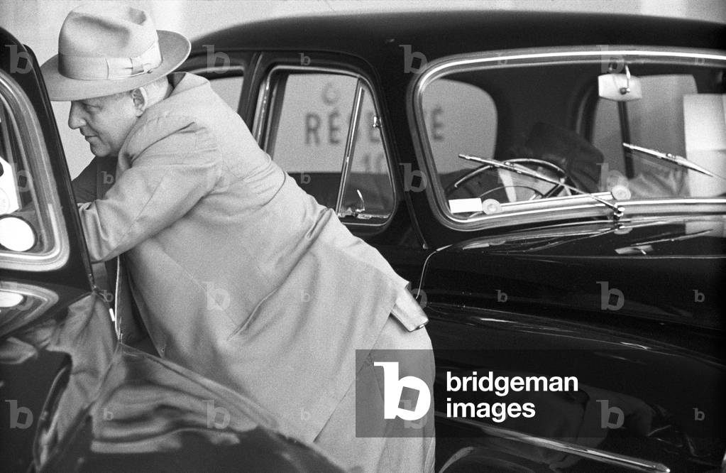 A man leaning against a car at the Geneva Summit, Geneva, Switzerland