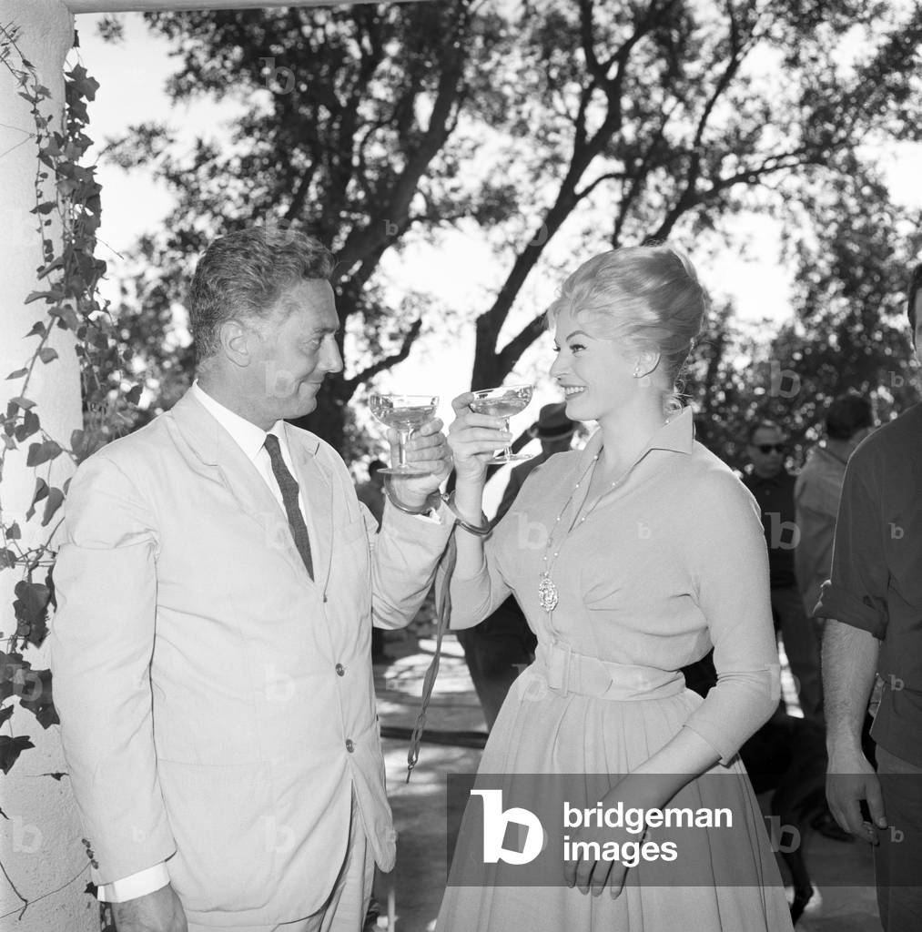 Anita Ekberg and Dino Risi toasting on the set of Behind Closed Doors, Italy, 1960 (b/w photo)