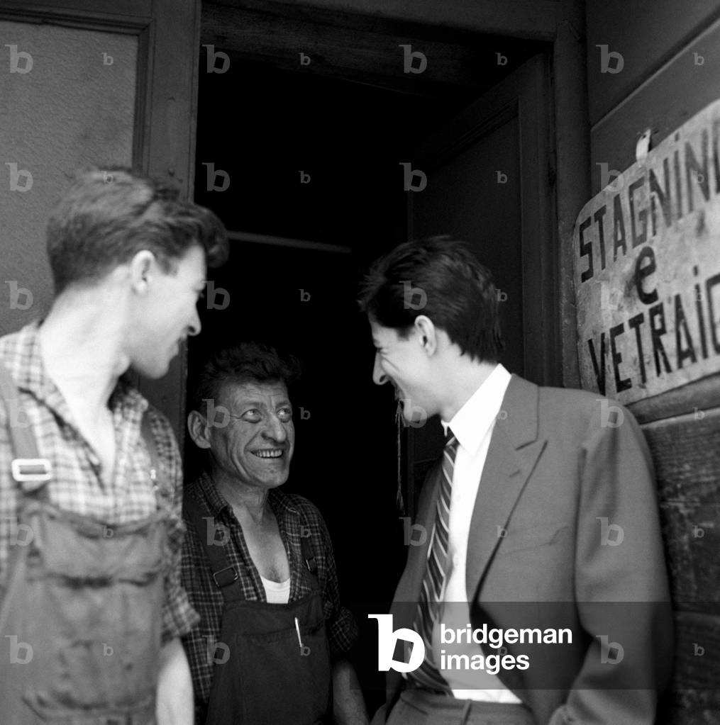 Giorgio Gaber smiling with the workers of a workshop