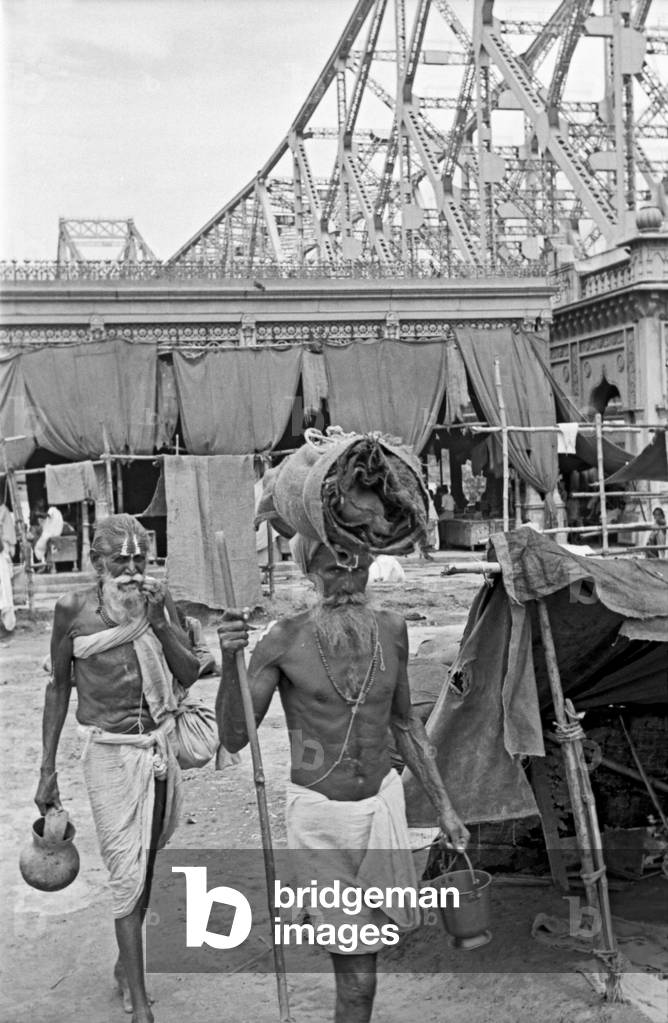 Two Hindu ascetics walking near the Howrah Bridge, Kolkata, India, 1962 (b/w photo)