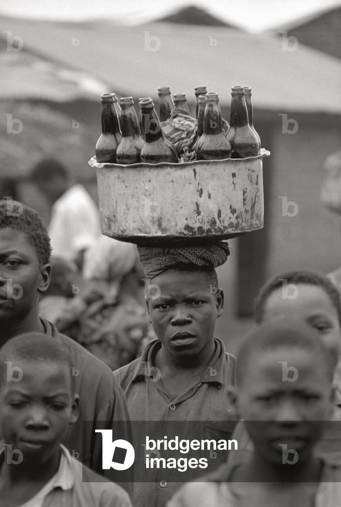 African boy carrying some bottles