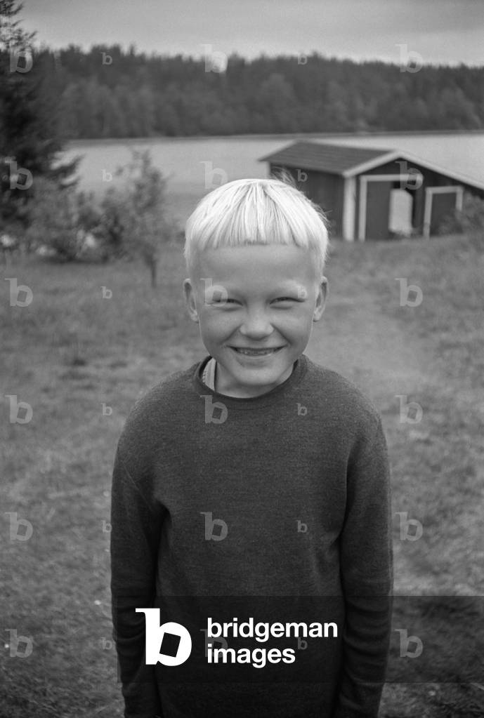 A child posing smiling, Finland, 1960s (b/w photo)