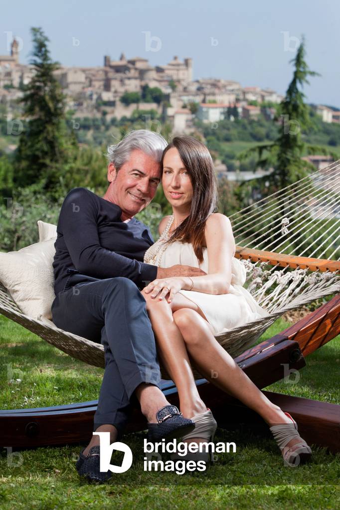 The stylist and entrepreneur Cesare Paciotti sits on a hammock with his wife, Laura Leonori, in the garden of their country house in Civitanova Marche. Civitanova Marche, Italy, 2011 (photo)