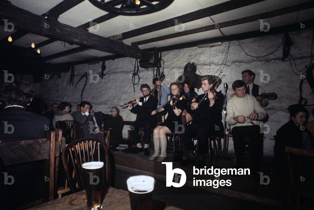 A celtic band is playing live music in a pub in Dublin