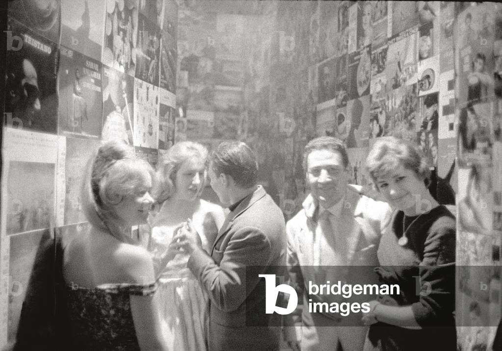 Young people in a room plastered over with posters