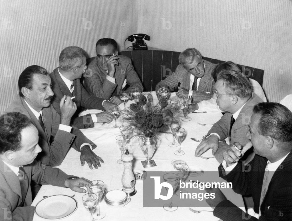 William Faulkner sitting at the table with Alberto Mondadori, Enzo Biagi and Elio Vittorini