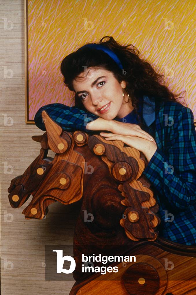Cristina D'Avena posing with a wooden horse, Italy, 1988 (photo)