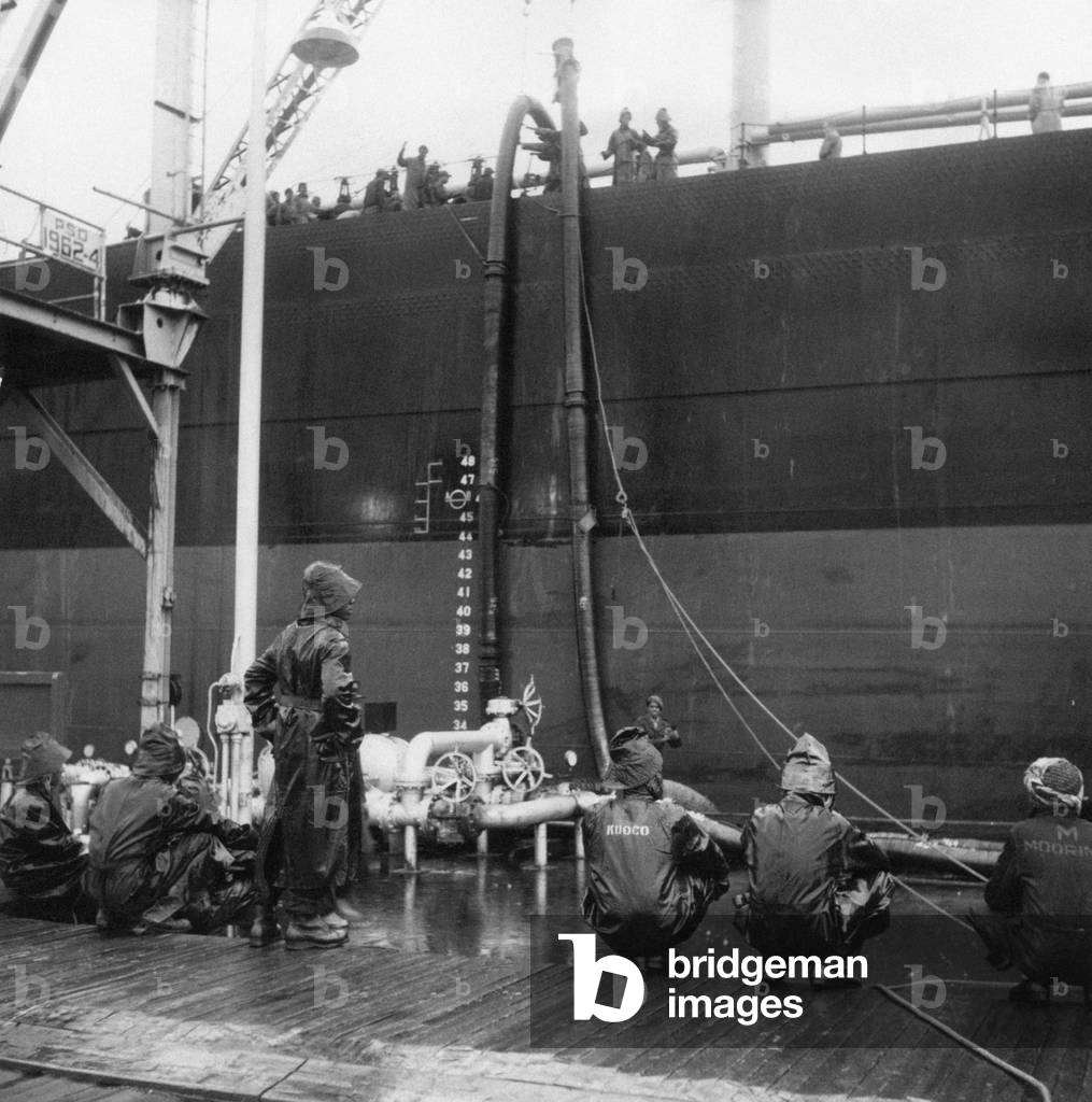 Workers control the flow of oil to the oil tanker Universe Leader, Ahmadi, Kuwait