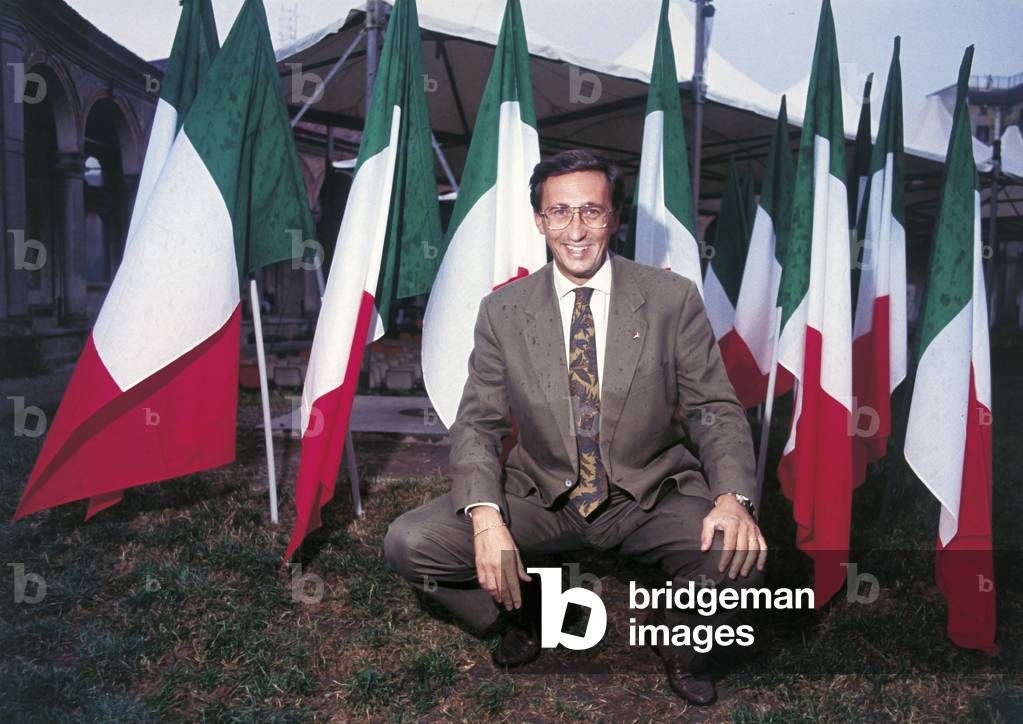 Gianfranco Fini in front of Italian flags