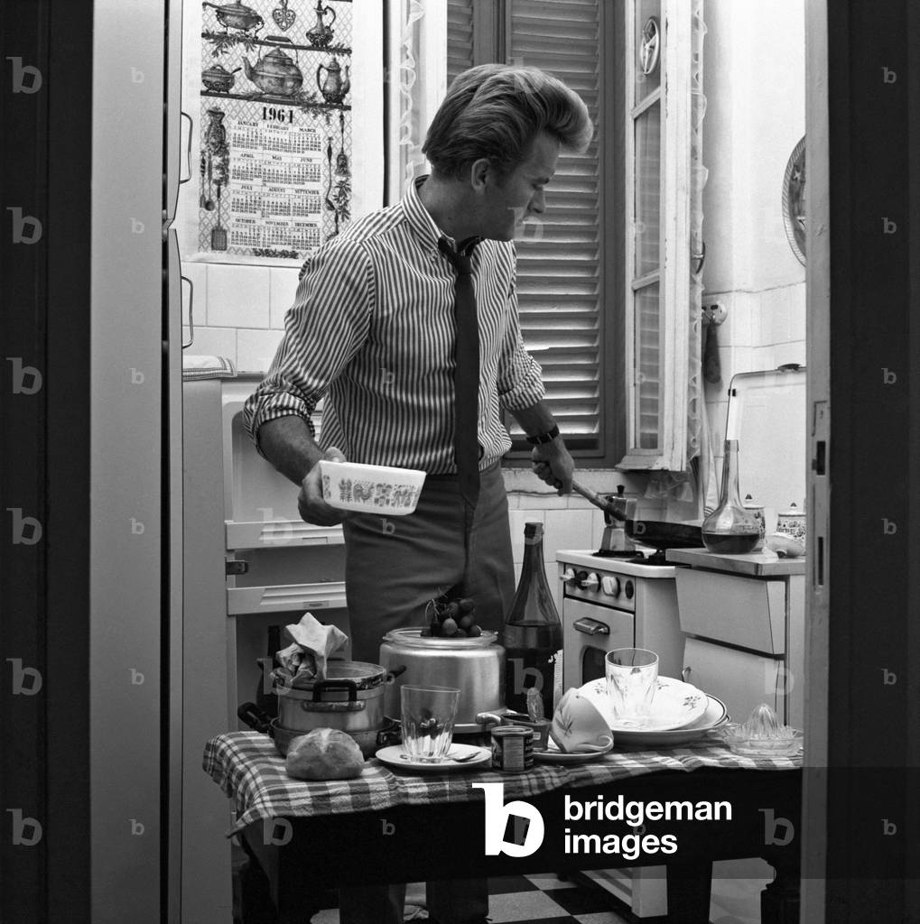 A young man cooking in the disorder, Italy