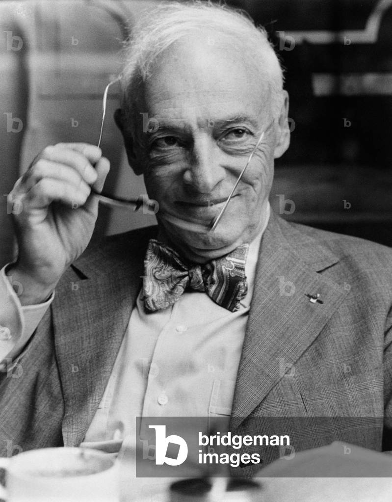 Writer Saul Bellow holds a pair of glasses in his hand