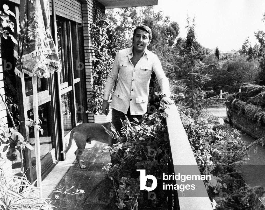 Pino Caruso is joking while posing in the balcony of his house
