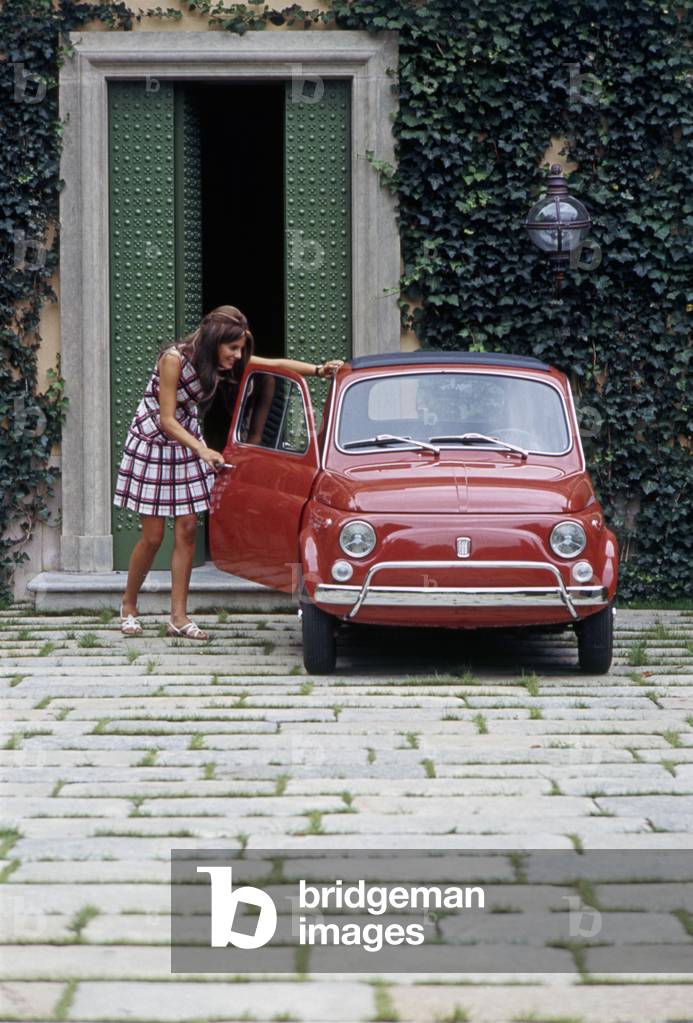 Girl opening the door of a Fiat 500 L, Italy