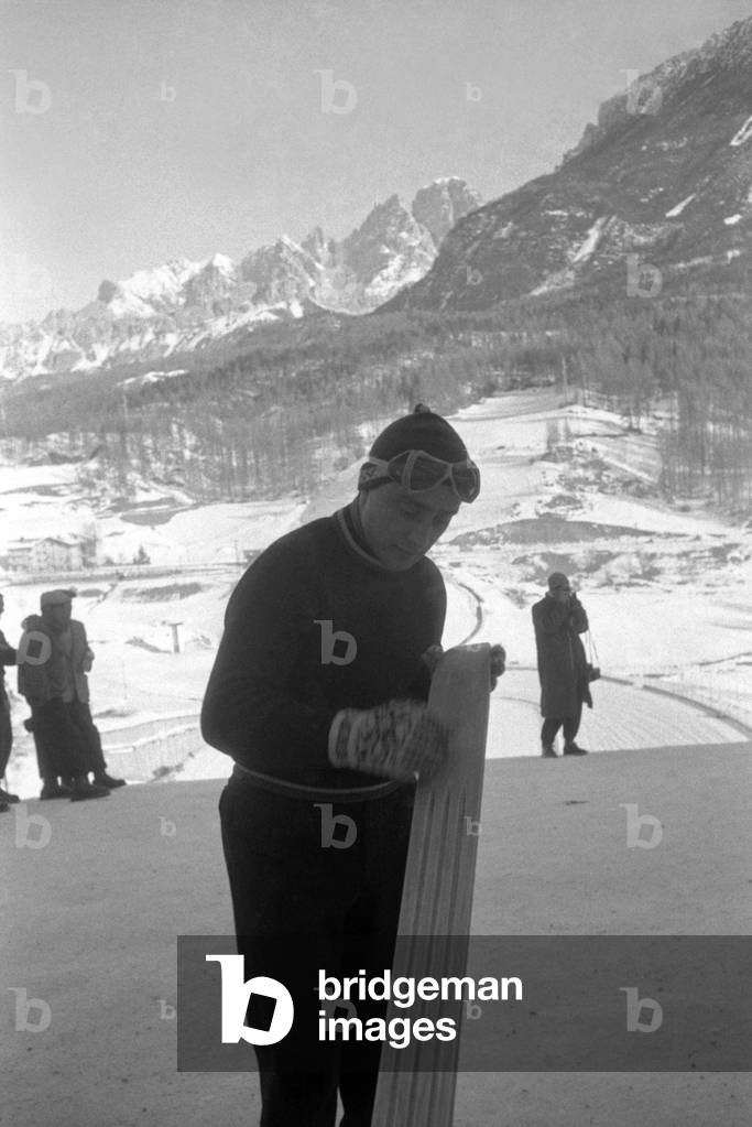 A skier checking the edge of his skis, Cortina d'Ampezzo, Italy