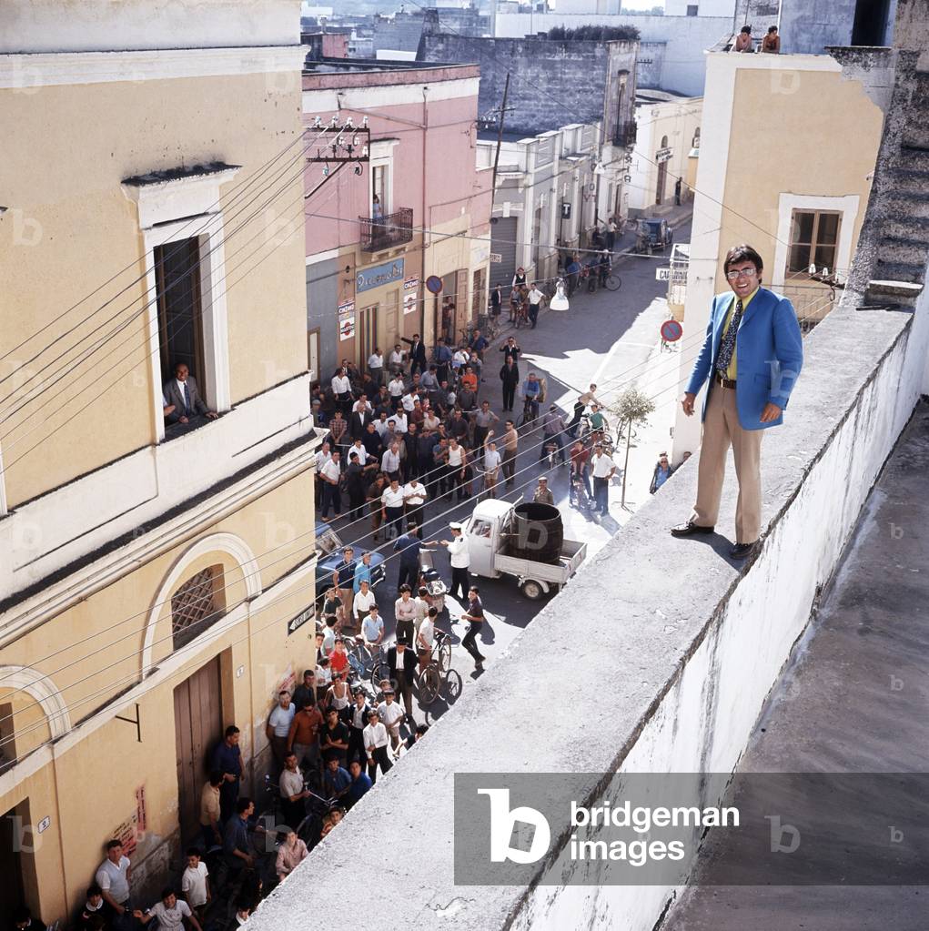 Al Bano poses standing on the ledge of a terrace, under the eyes of the crowd, Cellino San Marco, Italy