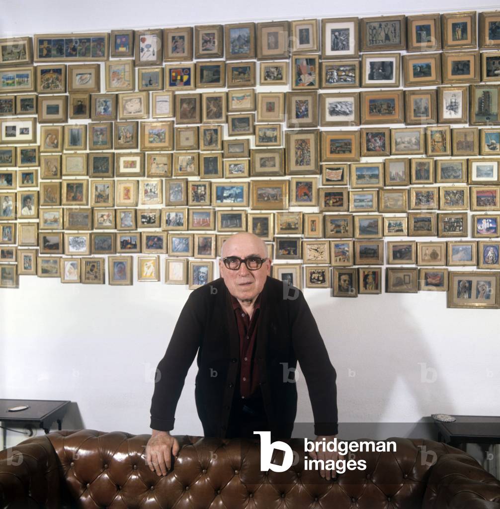 Cesare Zavattini in front of his collection of paintings