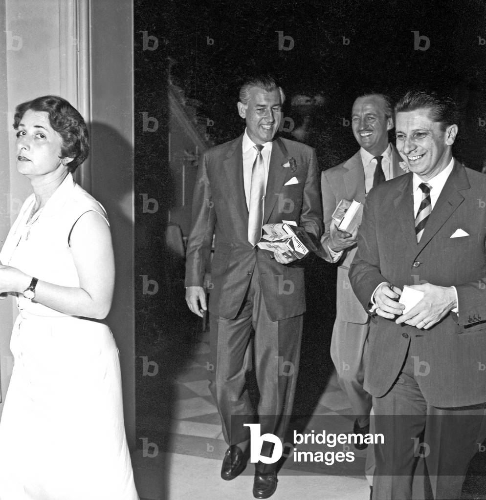 Stewart Granger and David Niven coming out of a hotel, Rome, Italy, 1956 (b/w photo)