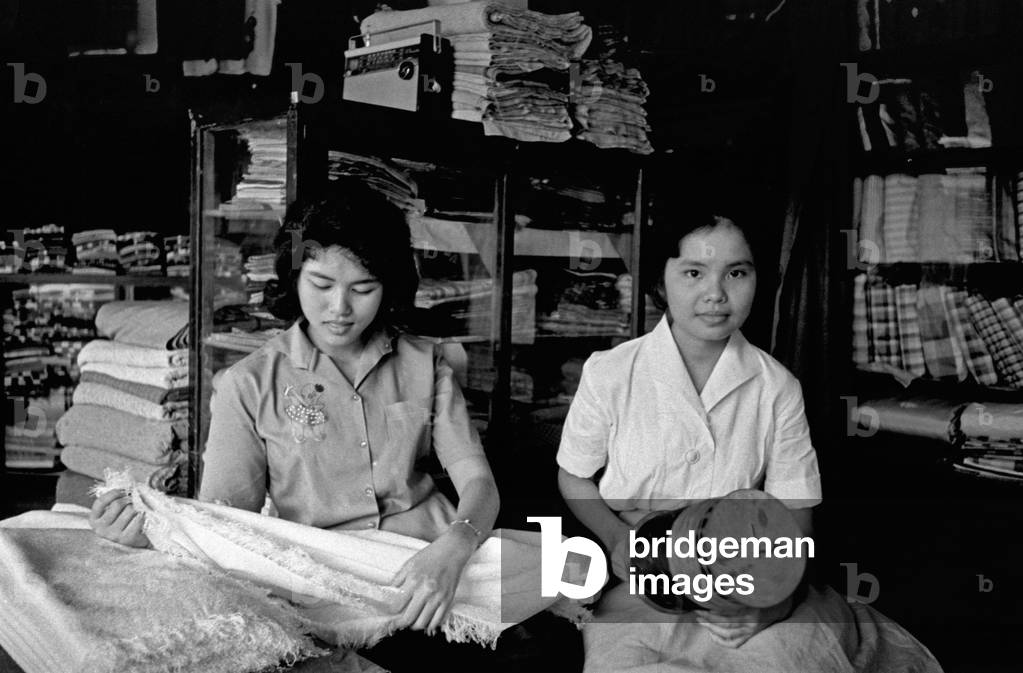 Two Thai girls working at a tailor's shop, Bangkok, 1961 (b/w photo)