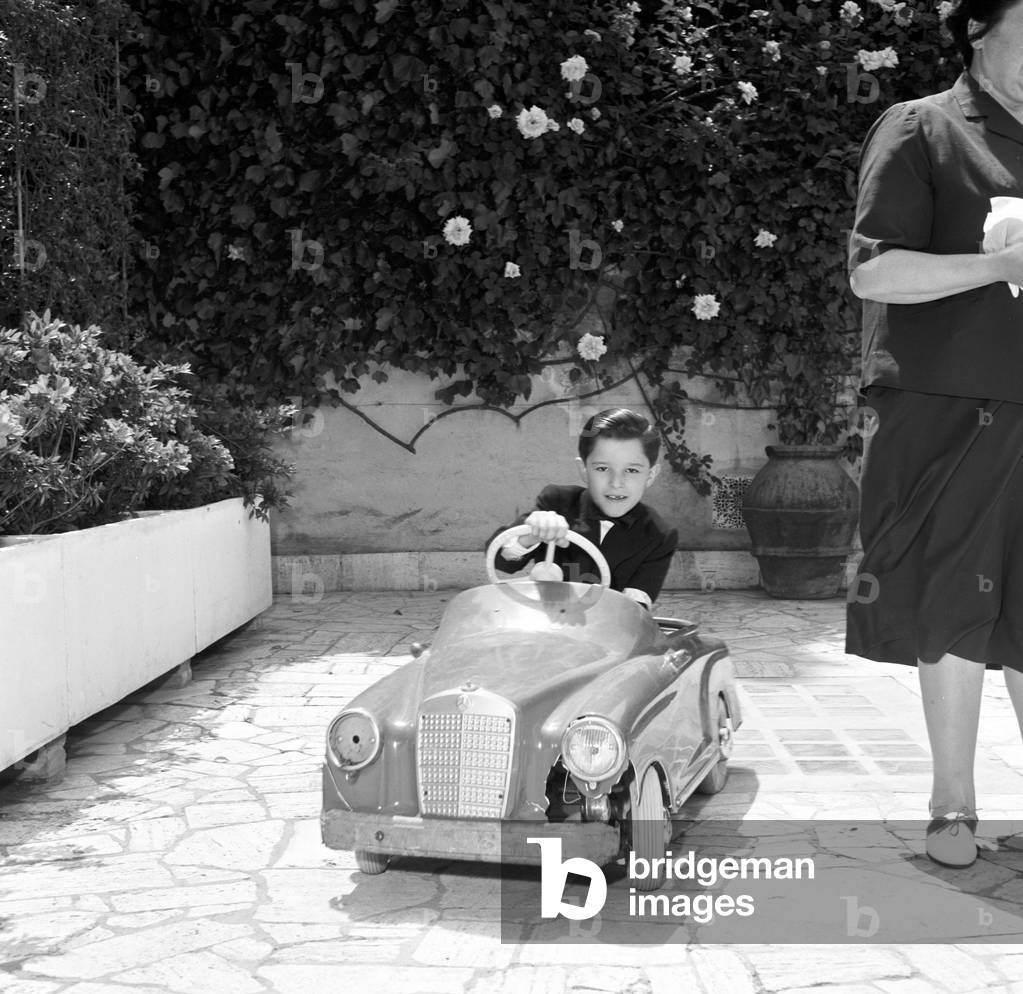 Christian De Sica playing with a toy car, Italy, 1958 (b/w photo)
