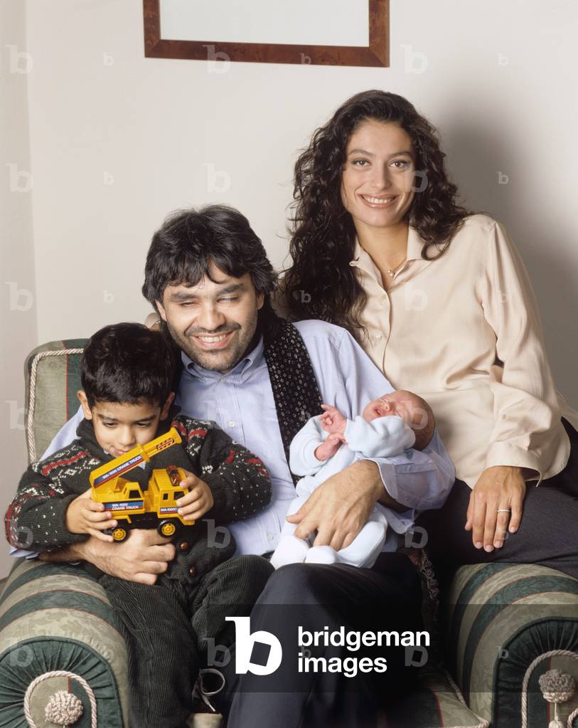Andrea Bocelli in an armchair with his wife Enrica Cenzatti and their childre Amos and Matteo