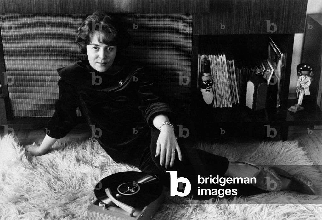 Jula De Palma sat down and relaxing on a carpet, 1961 (b/w photo)