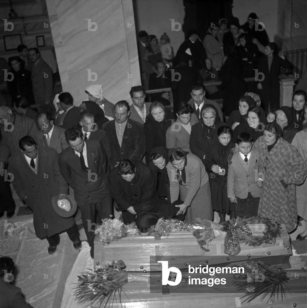 A woman crying on a coffin at the funeral of the victims of Marcinelle, Manoppello, Italy