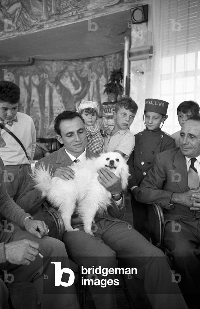 Ercole Baldini caressing a dog, Magreglio, Italy