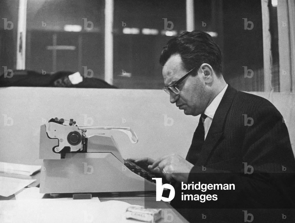 Italian journalist and vice-editor in chief of the weekly magazine Epoca Domenico Agasso writing an article on a typewriter, Verona, 1964 (b/w photo)