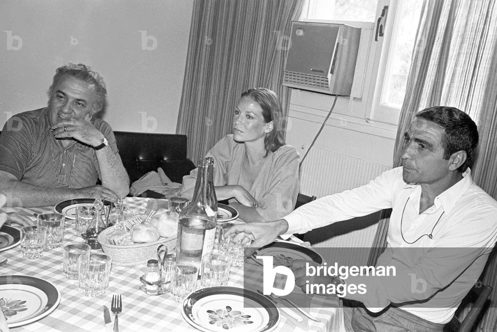 Federico Fellini and Giuseppe Rotunno sitting at a table, Italy, 1976 (b/w photo)