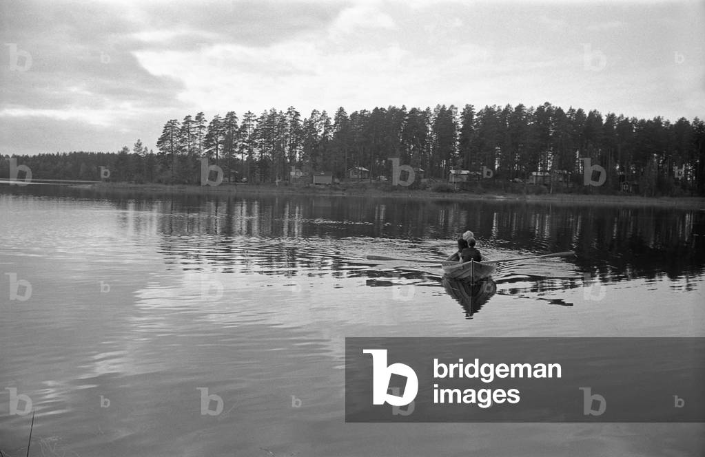 A rowing boat sailing a Finnish lake, Finland, 1960s (b/w photo)