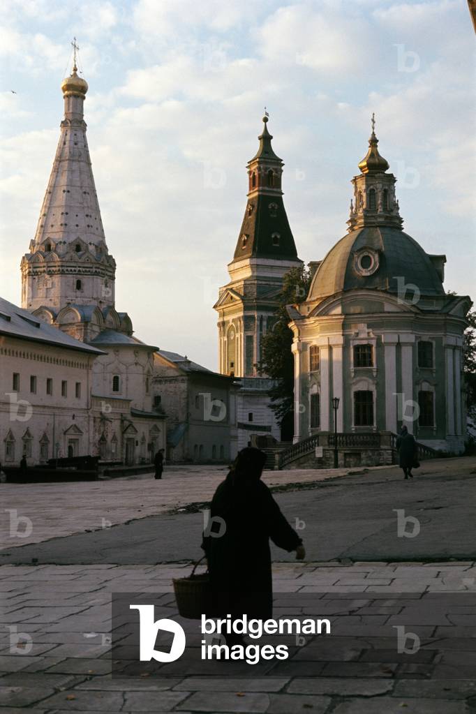 An old woman walks with a basket in her hand at the Trinity Lavra of Saint Sergius in Zagorsk, Zagorsk, Russian Federation
