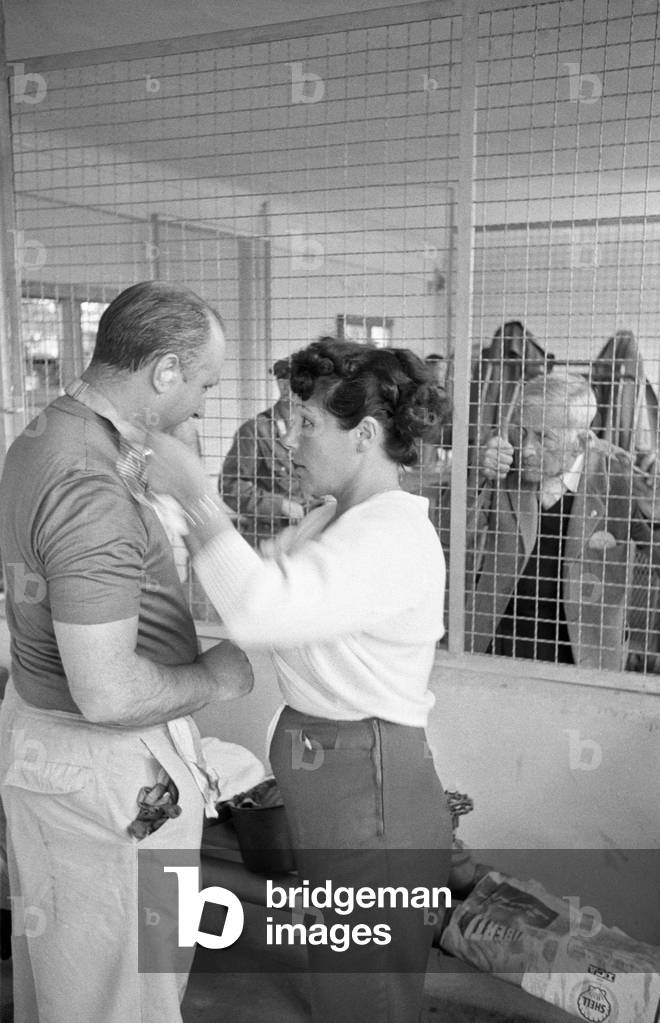 Argentinian car driver Juan Manuel Fangio's wife Andrea Berruet wishing good luck to her husband before the Italian Grand Prix, Monza, Italy, 2nd September 1956 (b/w photo)